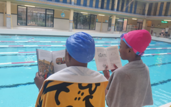 Jeunes filles lisant un livre à la piscine