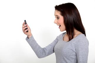 Jeune femme ravie devant son mobile
